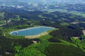 Reservatório superior artificial de uma usina hidrelétrica reversível no alto de um morro cercado de floresta